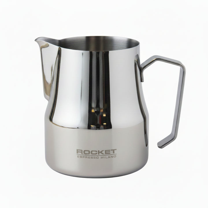 A polished stainless steel milk pitcher with a built-in handle and spout, featuring the 'ROCKET ESPRESSO MILANO' logo printed on the lower front, set against a neutral light gray background.